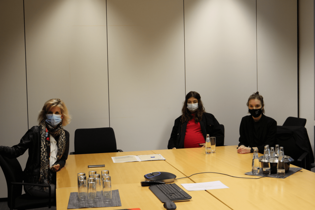 Bundesdrogenbeauftragte Daniela Ludwig sitzt mit Zhana Jung und Philine Edbauer am Konferenztisch: Foto von der Übergabe der Petition